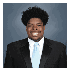 A man wearing a suit and tie is smiling for the camera. AI generated content
