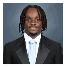 A young man wearing a suit and tie smiles for the camera. AI generated content