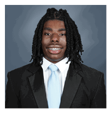 A young man wearing a suit and tie is smiling for the camera. AI generated content