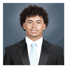 A young man wearing a suit and tie is smiling for the camera. AI generated content