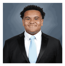 A young man wearing a suit and tie is smiling for the camera. AI generated content