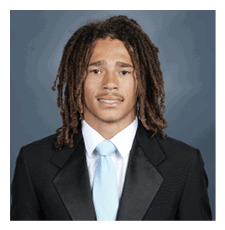 A young man wearing a suit and tie is smiling for the camera. AI generated content