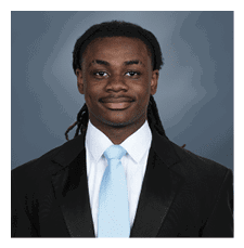 A young man wearing a suit and tie is smiling for the camera. AI generated content
