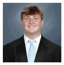 A young man wearing a suit and tie is smiling for the camera. AI generated content