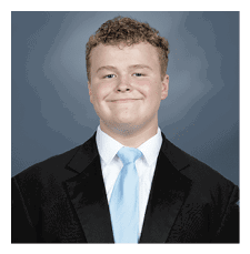 A young man wearing a suit and tie is smiling for the camera. AI generated content