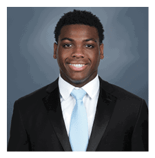 A young man wearing a suit and tie is smiling for the camera. AI generated content
