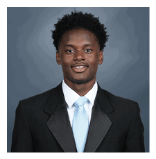 A young man wearing a suit and tie is smiling for the camera. AI generated content