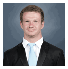 A young man wearing a suit and tie poses for a picture. AI generated content
