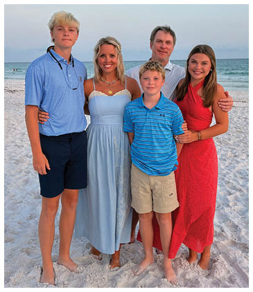 A family of five poses for a photo on a beach. AI generated content