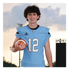 A young man in a blue football uniform is holding a football. AI generated content