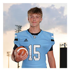 A football player wearing a blue and white uniform stands on a field holding a football. AI generated content