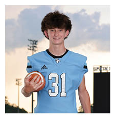 A young man wearing a football uniform stands on a field holding a football. AI generated content