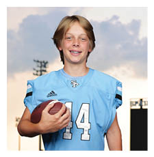 A young boy wearing a football uniform and holding a football. AI generated content