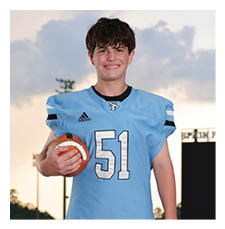 A young man in a blue football uniform is holding a football. AI generated content