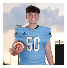 A young man wearing a football uniform stands on a field holding a football. AI generated content