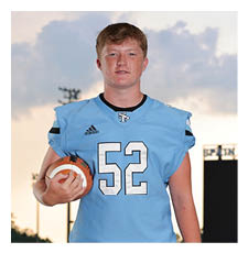 A football player in a blue jersey holding a football. AI generated content