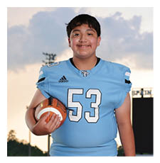 A young man wearing a football uniform and holding a football. AI generated content