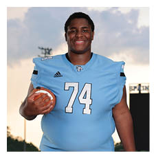 A man wearing a blue football jersey with the number 74 on it is holding a football. AI generated content
