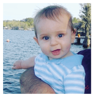 A baby is sitting in a person's arms, looking at the camera. AI generated content