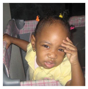 A young girl is sitting in a baby carrier, looking down with her hands on her face. AI generated content