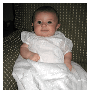 A baby wearing a white dress is sitting on a couch. AI generated content