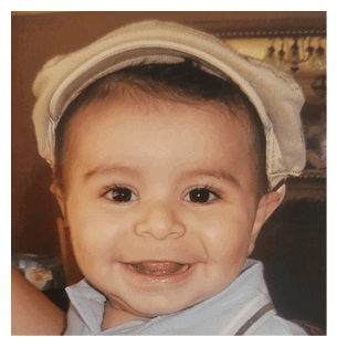 A young boy wearing a blue shirt and a hat is smiling for the camera. AI generated content
