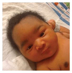 A baby with dark hair and dark eyes is lying on a white sheet. AI generated content