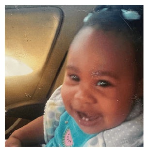 A young child is sitting in a car seat, smiling and wearing a blue and white shirt. AI generated content