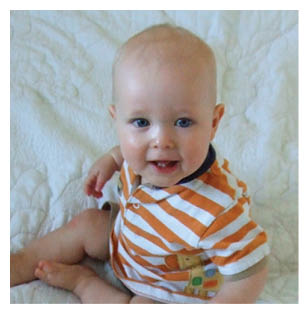 A baby is sitting on a bed, wearing a striped shirt and smiling. AI generated content