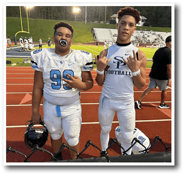 Two football players wearing white uniforms and holding footballs. AI generated content