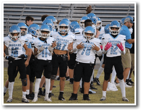 A group of young boys wearing football uniforms pose for a picture. AI generated content
