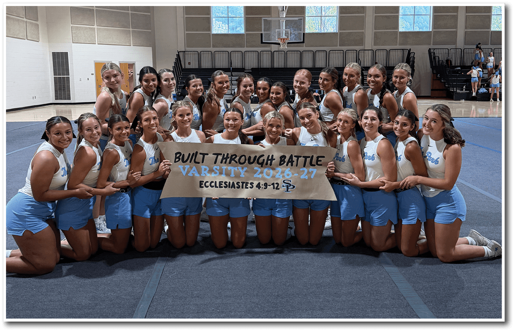A group of cheerleaders pose for a picture in front of a banner. AI generated content