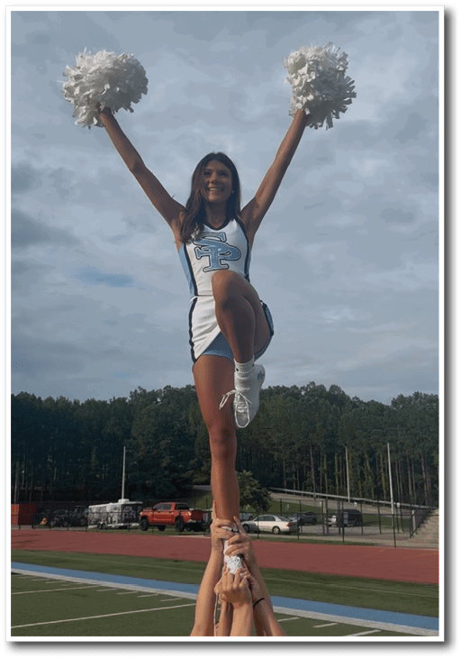 A cheerleader is performing a stunt by standing on the shoulders of other cheerleaders. AI generated content