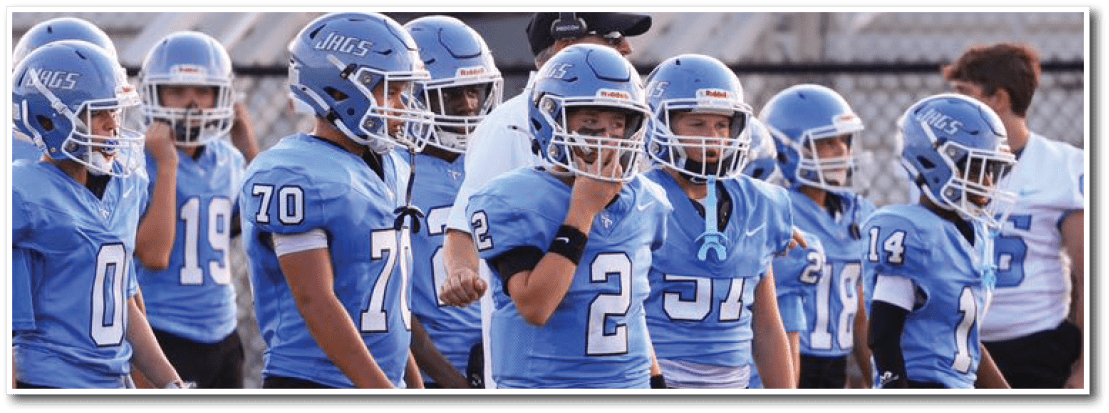 A group of young boys wearing blue jerseys and black shorts are standing on a field. AI generated content