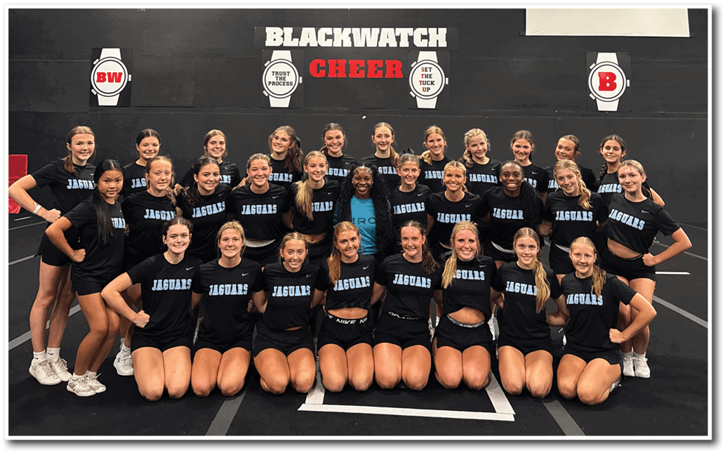 A group of cheerleaders pose for a photo in front of a banner. AI generated content