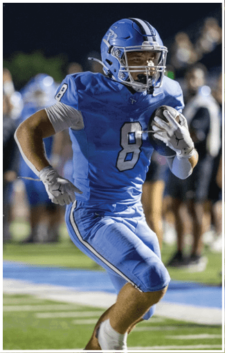 A football player wearing a blue jersey with the number 8 runs with the ball. AI generated content