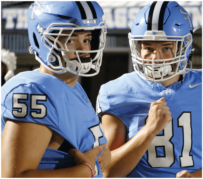 Two football players wearing blue uniforms and helmets. AI generated content