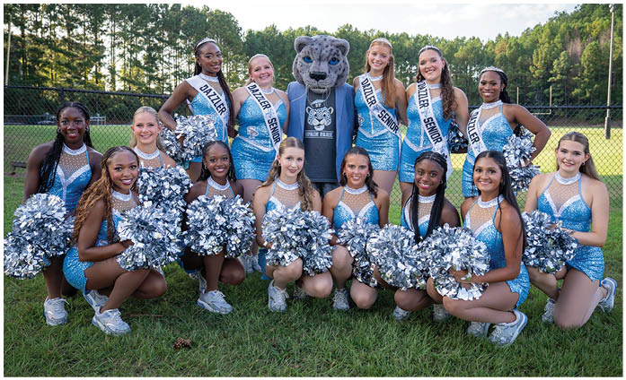 A group of cheerleaders pose for a picture with a mascot. AI generated content