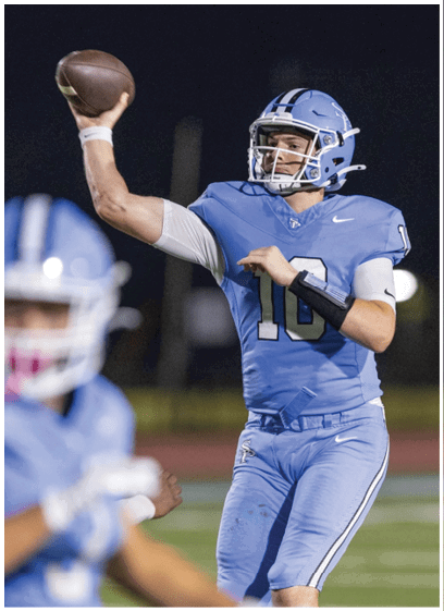 A football player in a blue uniform is throwing a football on a field. AI generated content
