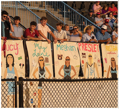 A group of people are holding up signs with the names of female athletes. AI generated content