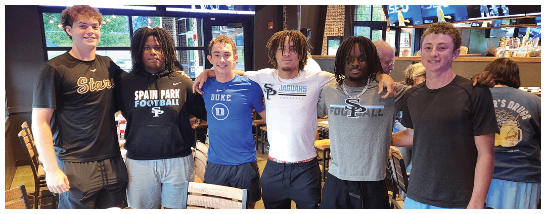 A group of young men pose for a picture in a restaurant. AI generated content
