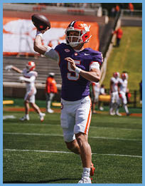 A football player in a purple jersey with the number 5 on it is throwing a football on a field. AI generated content
