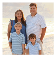 A man, woman, and two children pose for a picture on the beach. AI generated content