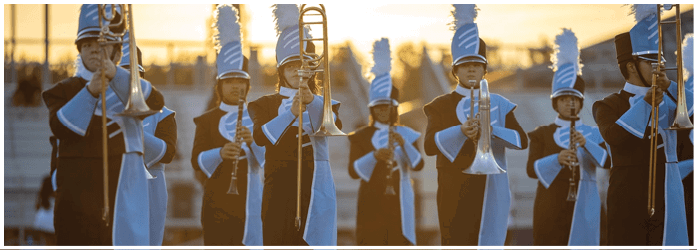 A group of brass musicians are standing on a field, playing their instruments. AI generated content