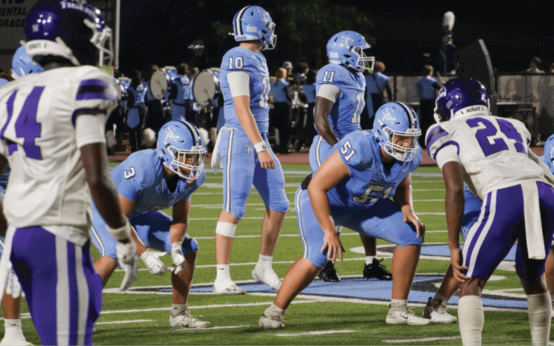 A group of football players in blue uniforms are on the field. AI generated content
