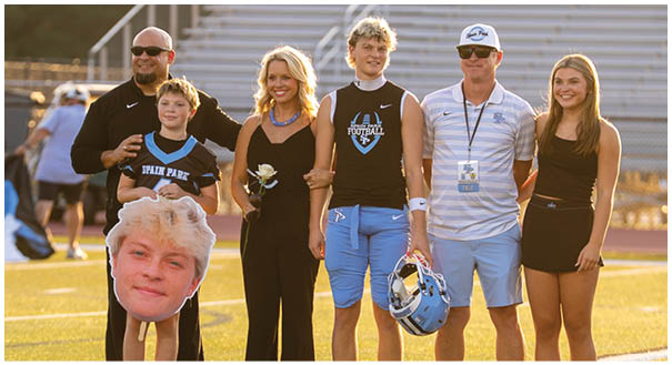 A group of people posing for a picture on a football field. AI generated content