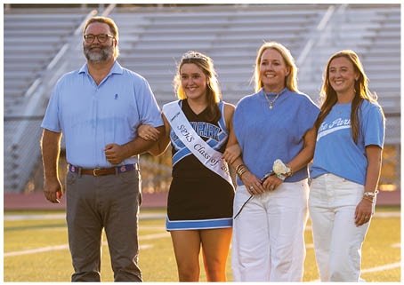 A group of people, including a woman in a blue dress, are standing on a field. AI generated content