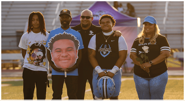 A group of people posing for a photo on a football field. AI generated content