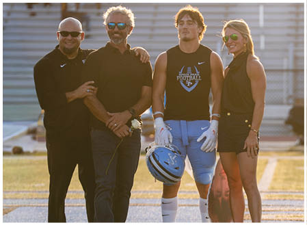 A group of people, including a football player, pose for a photo on a field. AI generated content