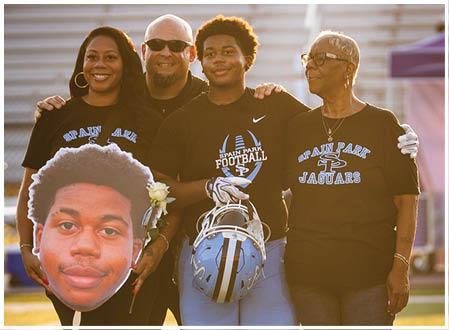 A group of people posing for a photo, one of them holding a football helmet. AI generated content